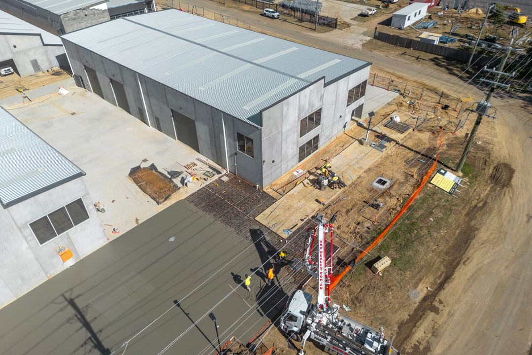 E-Hub Estate, Raceview — a crane setting a precast panel during construction
